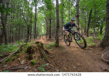 Mountain biker flies through the lush forest greenery on the trail in Lake James park, North Carolina. These trails are fast flowing and enjoyable, providing sport, fitness, motivation and inspiration