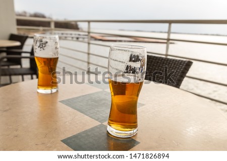summer terrace cafe, a couple of glasses of beer stand on the table against the lake