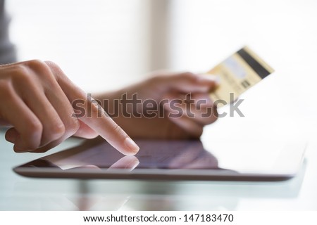 Woman shopping using tablet pc and credit card .indoor.close-up Royalty-Free Stock Photo #147183470