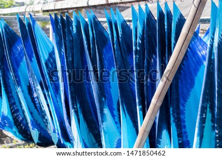 Colorful fabric hanging to dry after traditional dye process