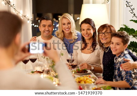 celebration, holidays and people concept - happy family having dinner party at home and taking selfie by smartphone