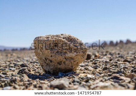 Closeup of rough round rock on gravel.