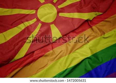 waving colorful gay rainbow flag and national flag of macedonia. macro