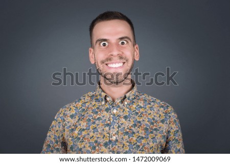 Young handsome man wearing vintage shirt having broad white smile being excited to meet Friends and go out to have a good day.