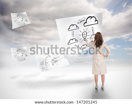 Businesswoman drawing on a floating paper with blue sky on the background