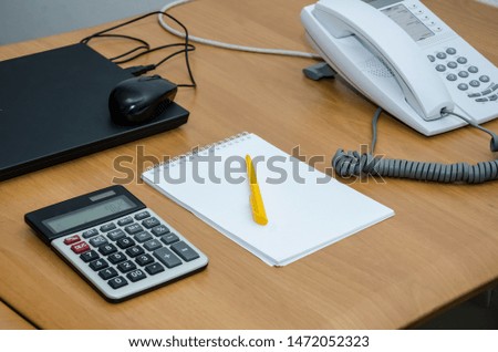 office concept. Notebook, pen, calculator, laptop and office phone on the table