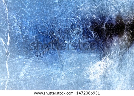 Abstract Grunge Rough Cracked Uneven Textured Vintage Blue Stucco Wall Background. Background with extremes in lighting. Copy space.