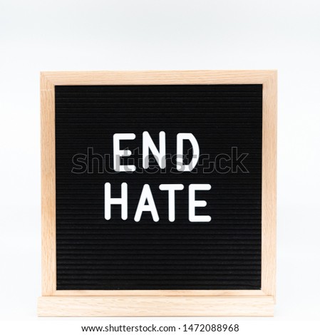 Text in english spelling 'End Hate' on black felt board in a wooden frame. Letter Board on white background. A sign with a message
