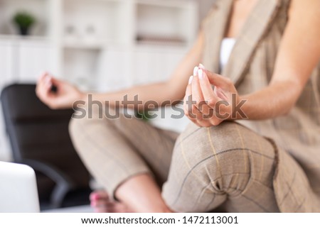 Closeup of businesswoman meditating in lotus position. Selective focus