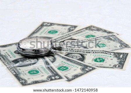 Dollars and stopwatch. Business concept of lost time and failed investments. Dollar bills in the rain. White background.