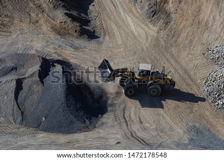 Excavator loading bucket on mining site stock photo