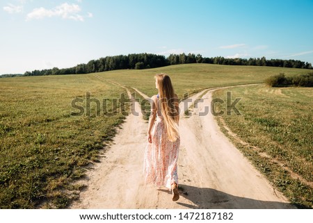 woman in front of two roads thinking deciding hoping for best taking chance Royalty-Free Stock Photo #1472187182