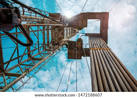Oil and Gas Drilling Rig onshore dessert with dramatic cloudscape. Oil drilling rig operation on the oil platform in oil and gas industry. Royalty-Free Stock Photo #1472188607