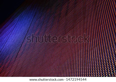 Macro photo of moving image on LED screen in a random moment consisting of RGB pixels. Abstract industrial, scientific or technology background resembling stars or spot lights glowing in darkness.