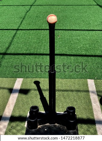 Baseball sitting on top of a batting tee Royalty-Free Stock Photo #1472218877