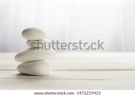 Stacked white stones on white background - Lifestyle and alternative health concept image with copy space for text. Royalty-Free Stock Photo #1472219423