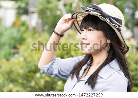 A Japanese woman in a hat travels in the mountains.
