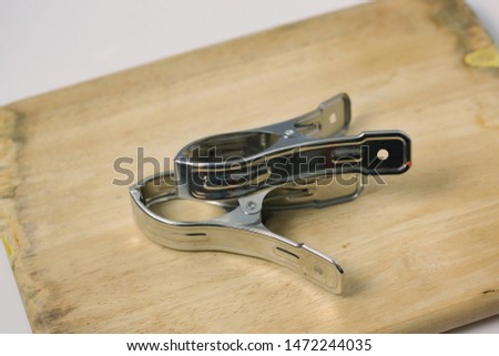 Big size linen or paper clips isolated with wood background.