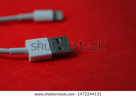 Lightning cable close up isolated red background