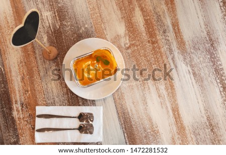 top view of orange cake, spoon, empty sign and copy space on vintage wooden table