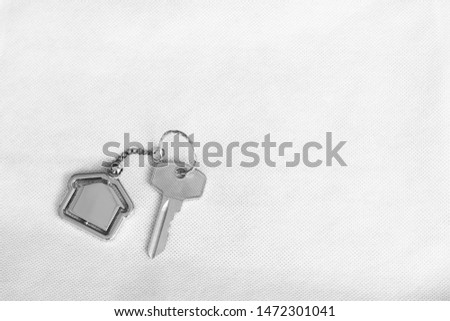 House key with home keyring in on white background, real estate concept, copy space