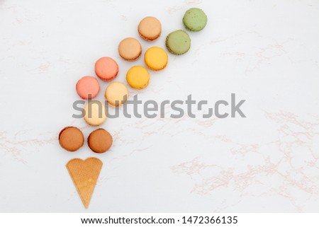 Fun flat lay composition of the colorful and sweet tasting small French cake macaron or macaroon combined with cookies