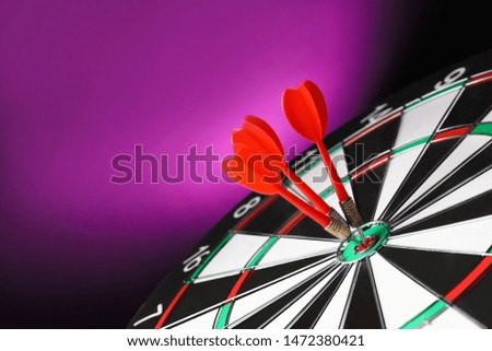 Red arrows hitting target on dart board against purple background. Space for text