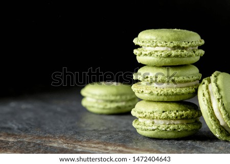 French dessert macaroons with pistachios and strawberries. Dark background