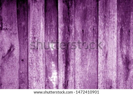 Weathered wooden fence in purple color. Abstract background and texture for design.