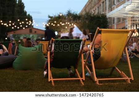 Modern open air cinema with comfortable seats in public park Royalty-Free Stock Photo #1472420765