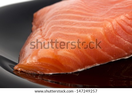 Yummy portion of salmon on the black plate