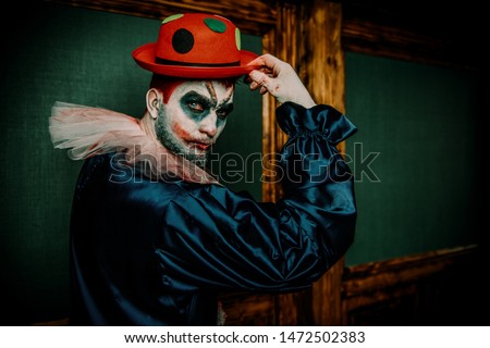 A portrait of an angry crazy clown from a horror film with a hat. Halloween, carnival.
