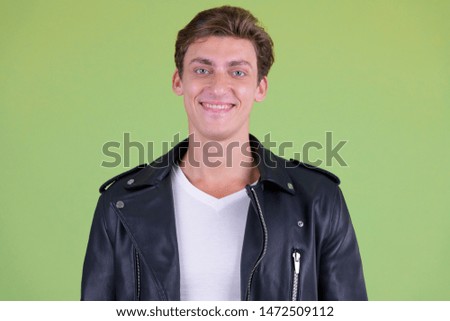 Face of happy young handsome rebellious man smiling