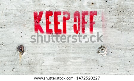background texture-rough cement wall with the words KEEP OFF in red block letters with copy space