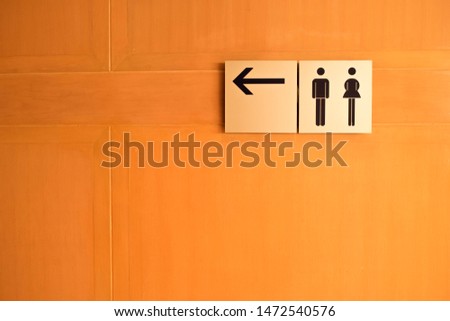 Toilet symbol with arrow on the wooden wall