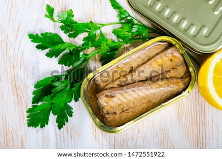 Picture of  tasty  fillet of mackerel  in sunflower oil with greens and lemon at table