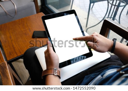 Close up of woman using blank tablet and credit card sending massages on the coffee shop.