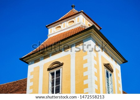 Tower at Medieval castle in Old center in Slovenska Bistrica near Maribor in Slovenia. Fortress in City travel in South Styria in Slovenija. Yellow Fort in Slovenian town. Blue sky and sunny day.