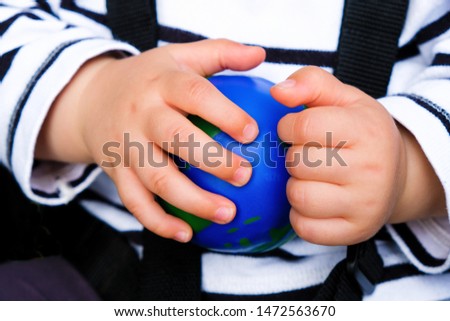 Ball globe in baby hands. The child is playing with a globe. Global world crisis. Changing the philosophy of life concept.
