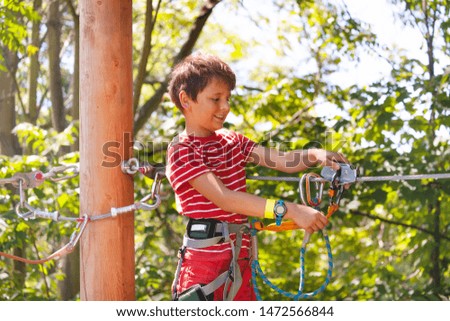 Happy boy learn to use zip line trolley, rope park