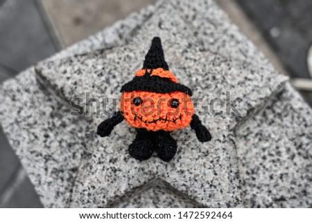 Halloween pumpkin man sits on a stone star