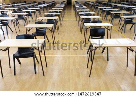 interior inside of an exam examination room or hall set up ready for students to sit test. multiple desks tables and chairs. Education, school, student life concept Royalty-Free Stock Photo #1472619347