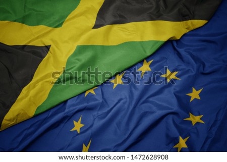 waving colorful flag of european union and flag of jamaica.  