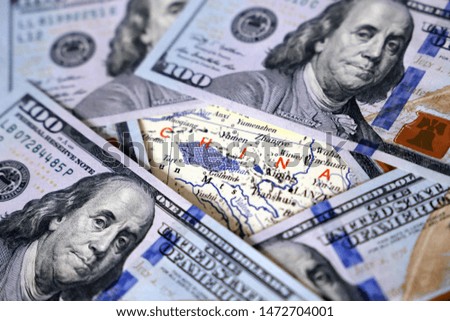US dollars on a map of China, selective focus. Concept of trade war between the Washington and Beijing, chinese economy, sanctions, tourism and investment