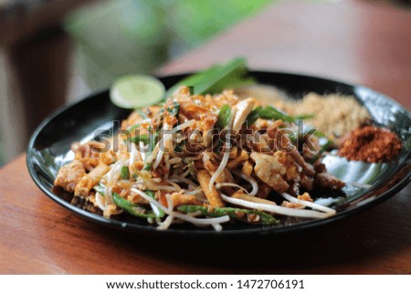 Pad Thai is in a black dish.Thai style noodles