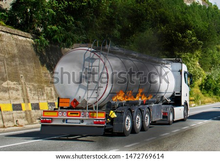 fire broke out at a tanker carrying diesel. Danger of explosion. Dangers that may occur to cars carrying fuel. Truck carrying fuel. Image with a fire. crack in fuel tank during transport Royalty-Free Stock Photo #1472769614