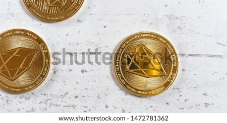 Top down view, golden commemorative EOS - EOSIO  cryptocurrency - coins on white stone board