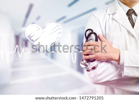 The doctor holds a stethoscope in the hospital lobby