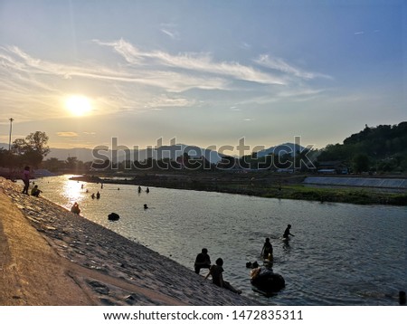 people life in the river under sunset