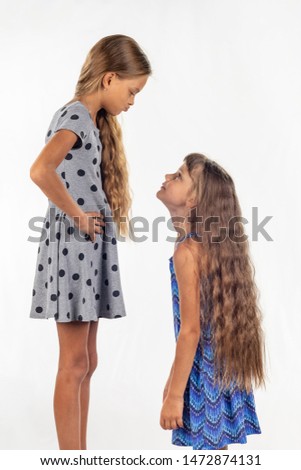 Two girls of different stature, one stood on a chair and became even taller Royalty-Free Stock Photo #1472874131